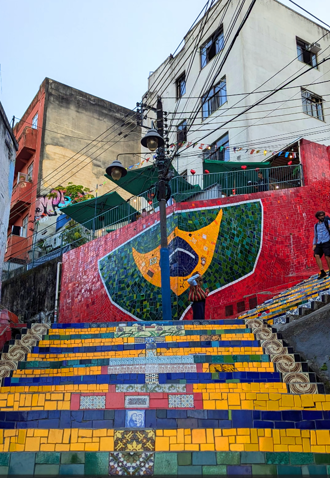 Colorful mural on a staircase with Brazilian flag design in an urban setting